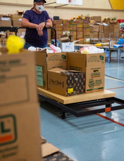 Volunteer pushing a cart with food boxes